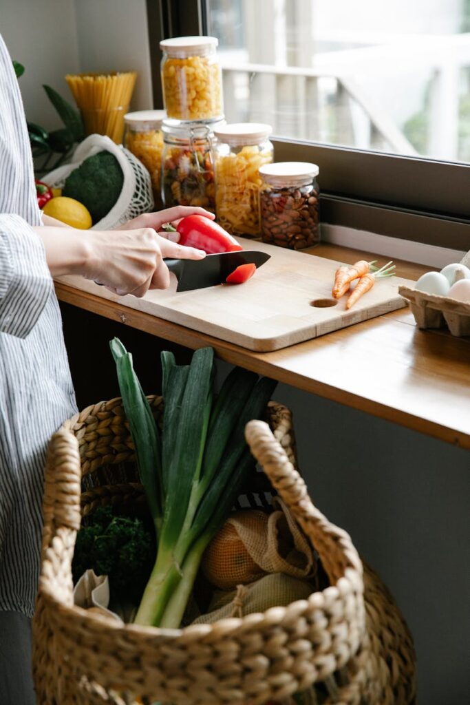 crop unrecognizable woman cutting vegetables in kitchen